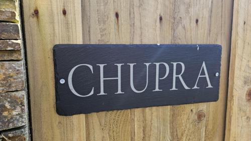 a sign that says charma on a wooden door at Chupra in Saint Mawes