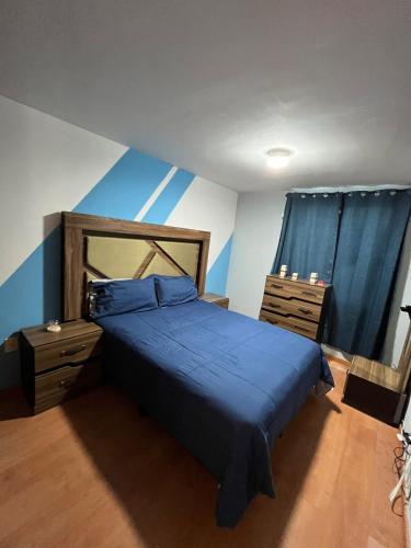 a bedroom with a blue bed and two dressers at Casa residencial Santa María in Oaxaca City