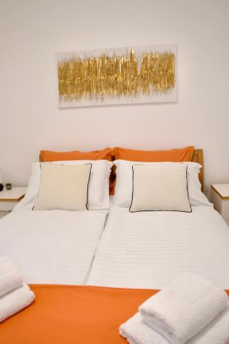 a white bed with two pillows on top of it at Apartman Marta in Klek