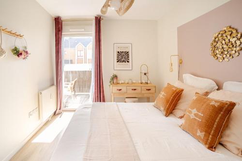 ein Schlafzimmer mit einem großen weißen Bett und einem Fenster in der Unterkunft F2 Ma Bohème classé 3 étoiles in Courcouronnes