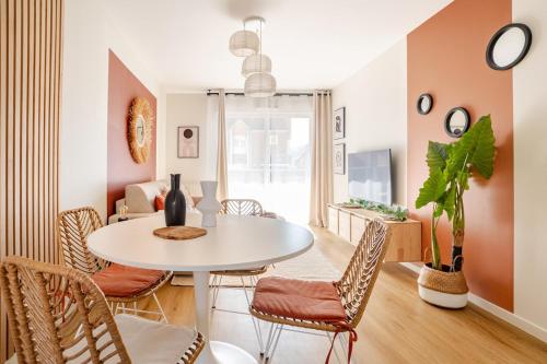 une salle à manger avec une table et des chaises blanches dans l'établissement F2 Ma Bohème classé 3 étoiles, Évry-Courcouronnes