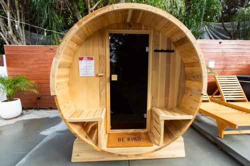 a circular wooden sauna with two chairs in it at Private House 3 min to beach large backyard Spa Sauna BBQ ! in San Juan Capistrano
