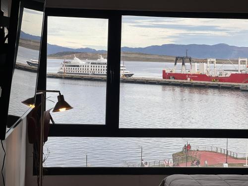 a view from a window of a river with a ship at Gray Fox Apartments - Marina in Ushuaia