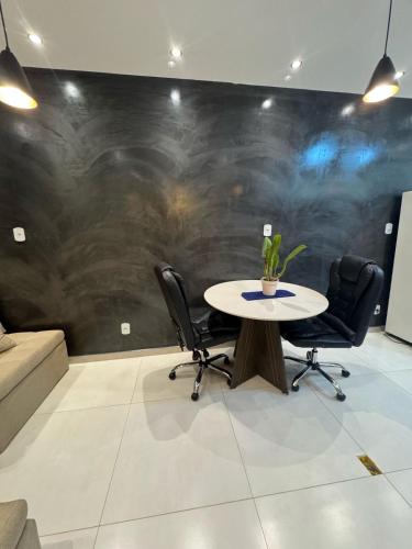 a table and chairs in a room with a wall at Pousada Recanto Querubins in Paty do Alferes