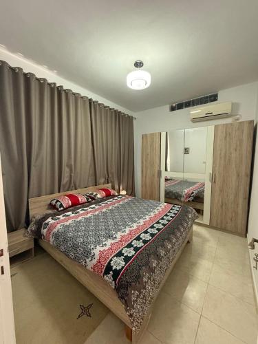 a bedroom with a large bed and a mirror at Maison independante taourit in Houmt Souk