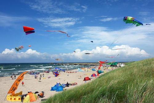 a group of people on a beach flying kites at Studio in uk cin 300m from Baltic Beach in Łukęcin