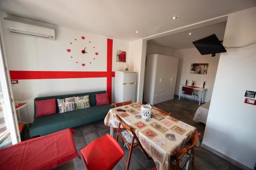 a living room with a green couch and a table at Disiu Case Vacanza in Balestrate