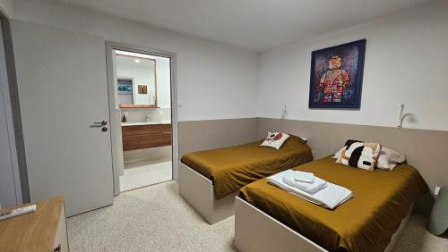 une petite chambre avec deux lits et un miroir dans l'établissement La Maison Bleue, à Saint-Mitre-les-Remparts