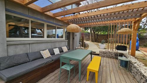 un patio avec un canapé, une table et des chaises dans l'établissement La Maison Bleue, à Saint-Mitre-les-Remparts
