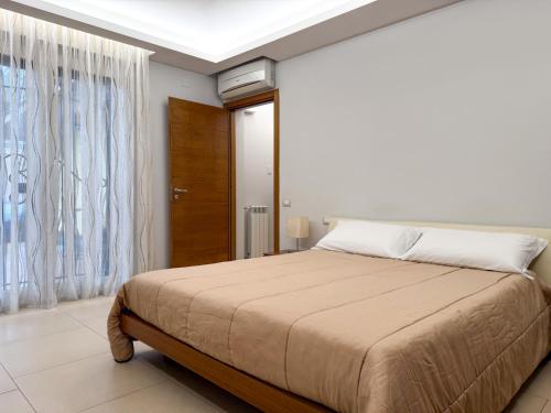 Un dormitorio con una cama grande y una ventana. en Etna Volcano House, en Belpasso