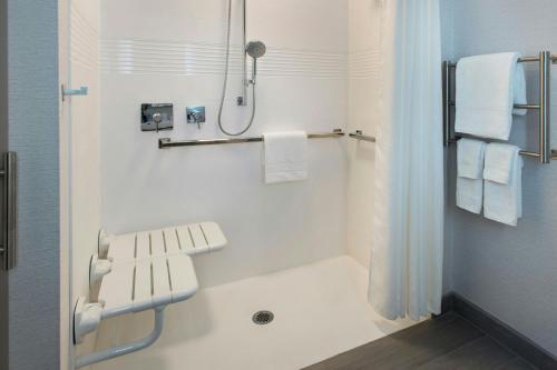 a white bathroom with a shower and a sink at TownePlace Suites by Marriott New York Brooklyn in Brooklyn