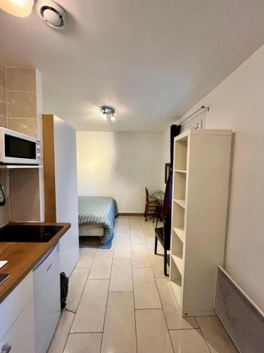 Il comprend une cuisine équipée d'un réfrigérateur et une chambre dotée d'un canapé. dans l'établissement Studio Confort à Montmartre, à Paris