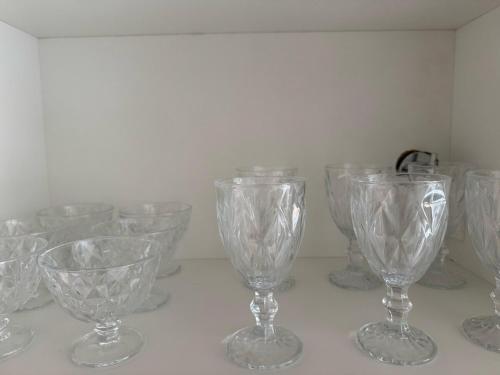a group of glass wine glasses sitting on a counter at Casa Arruda Climatizada 2 in Vitória da Conquista