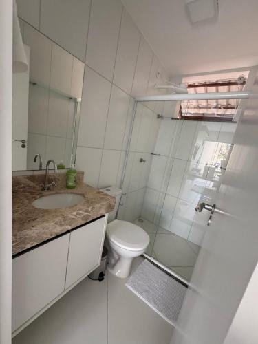 a white bathroom with a toilet and a sink at Casa Arruda Climatizada 2 in Vitória da Conquista