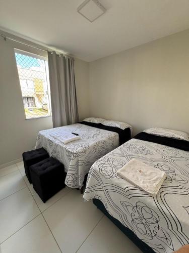 a bedroom with two beds and a window at Casa Arruda Climatizada 2 in Vitória da Conquista