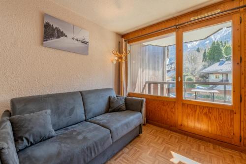 Una sala de estar con un sofá y una ventana grande. en Résidence Le Prarion 24A ski in- ski out - Happy Rentals, en Les Houches
