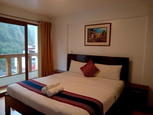 a bedroom with a bed with a large window at El Quetzal MachuPicchu in Machu Picchu