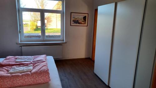 a bedroom with a bed and a window at Dorfstrasse 45 Sankt Annen in Sankt Annen