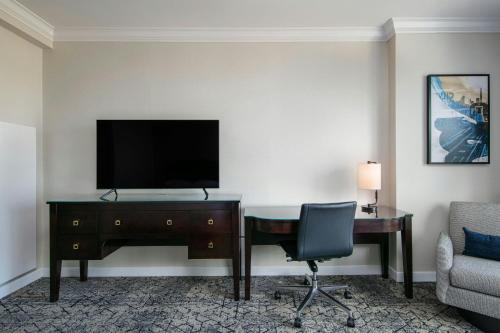 a hotel room with a desk and a television at Sheraton LaGuardia East Hotel in Queens