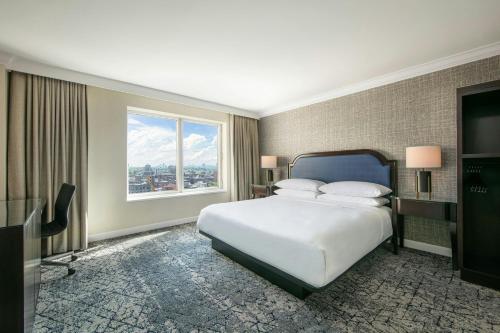 a bedroom with a bed and a large window at Sheraton LaGuardia East Hotel in Queens
