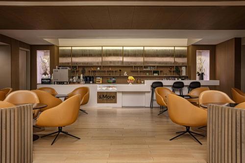 a restaurant with chairs and a counter and a kitchen at Sheraton LaGuardia East Hotel in Queens