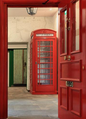 a red phone booth next to a red door at The Park in Peebles