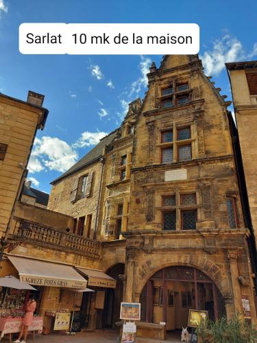 un vieux bâtiment en pierre avec les mots santa mile de la demeure de caractère dans l'établissement Maisonette paisible à La Roque-Gageac, à La Roque-Gageac