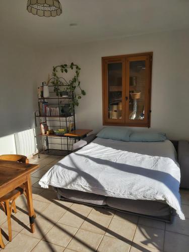 une chambre avec un grand lit et une table dans l'établissement Maisonette paisible à La Roque-Gageac, à La Roque-Gageac