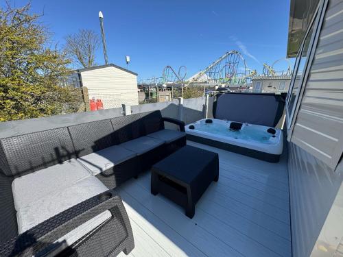a patio with a bench and a hot tub on a balcony at Fantasy Island Holiday Park Eastgate - The Seasons with Hot Tub - Coastal Caravan Breaks in Ingoldmells