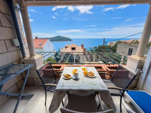a table with food on a balcony with a view of the ocean at Villa Leoni in Dubrovnik