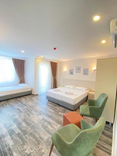 a bedroom with a bed and two green chairs at Dream Town Hotel&Restaurant in Kemer