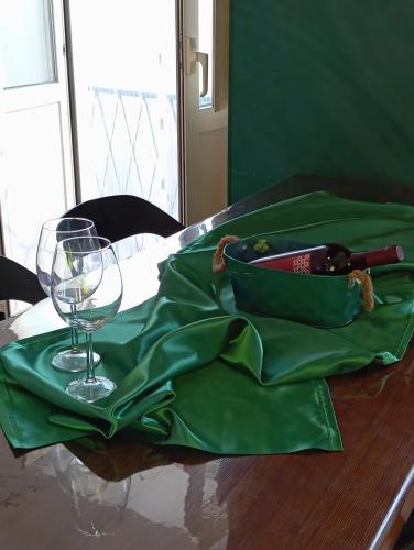 a green bag sitting on a table with a wine glass at Ortacolorhome GreenHome-Boleto in Madonna del Sasso