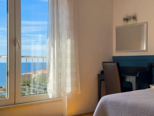 a bedroom with a window with a view of the ocean at Villa Leoni in Dubrovnik