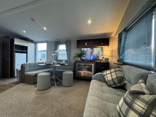 un soggiorno con un divano e una TV di Fantasy Island Holiday Park Eastgate - The Seasons with Hot Tub - Coastal Caravan Breaks a Ingoldmells