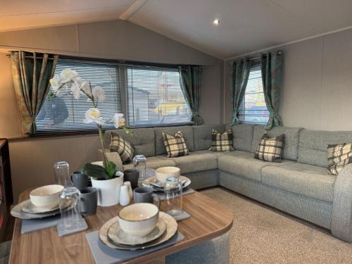 un soggiorno con un divano e un tavolo di Fantasy Island Holiday Park Eastgate - The Seasons with Hot Tub - Coastal Caravan Breaks a Ingoldmells
