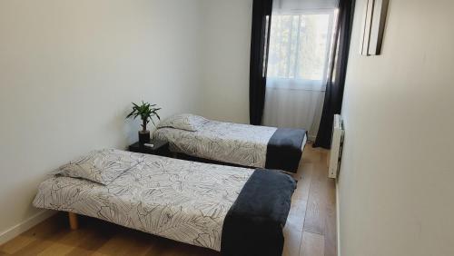 une chambre avec deux lits et une fenêtre dans l'établissement Spacieux T4 rénové en plein cœur de Hyères idéal pour des vacances en famille, à Hyères