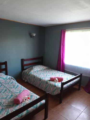 a small bedroom with two beds and a window at Va'a-va'a tea in Isla de Pascua