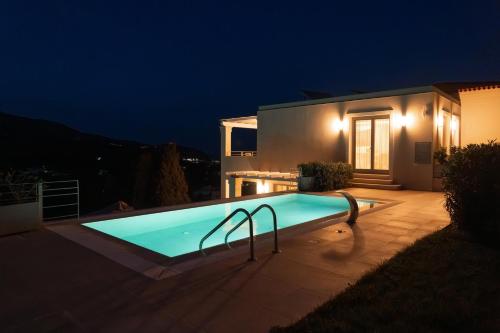 a swimming pool in front of a house at night at SuiteHome Villas with Private Pools by Explore Andros in Andros