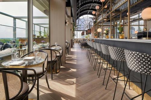 a row of tables and chairs in a restaurant at The Den, 's-Hertogenbosch, a Tribute Portfolio Hotel in Den Bosch