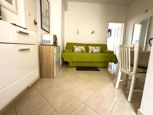 a living room with a green couch and a refrigerator at Villa Leoni in Dubrovnik