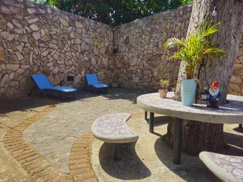 a patio with chairs and tables and a stone wall at Nica Valley in Rivas