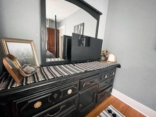 a dresser with a mirror on top of it at Come home to Kenwood Conveniently located Syracuse in Syracuse