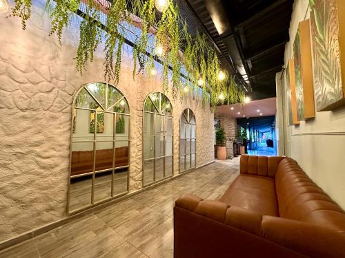 a lobby with a leather couch in a room at Hotel Londres in Valledupar