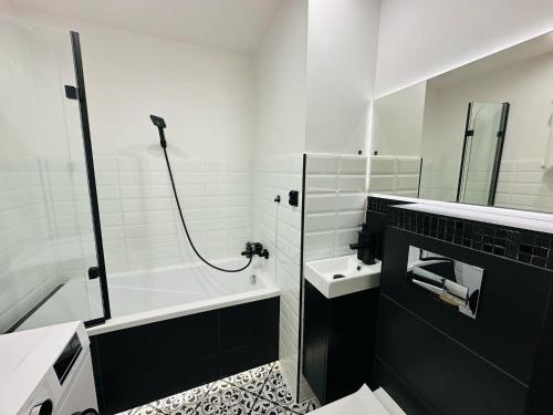 Un baño con bañera, lavabo y ducha. en Apartament pod Książem, en Wałbrzych