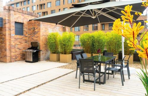 a patio with a table and chairs and an umbrella at Central Apartamentos Bogotá in Bogotá