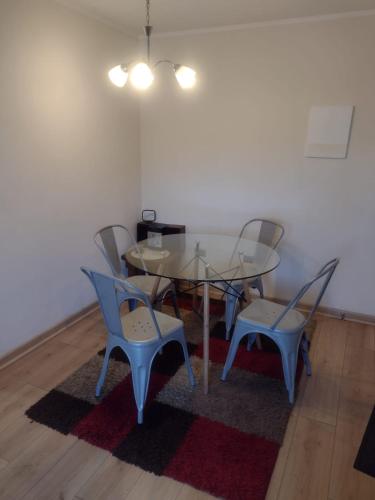 a dining room with a glass table and chairs at Acogedor Departamento en Temuco in Temuco