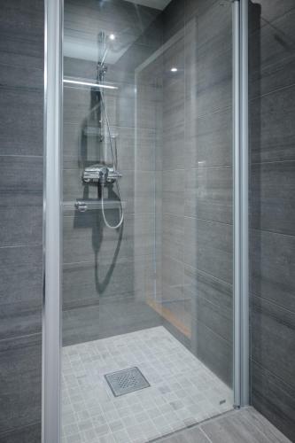 a shower with a glass door in a bathroom at Pluscamp Mageli in Bjørge