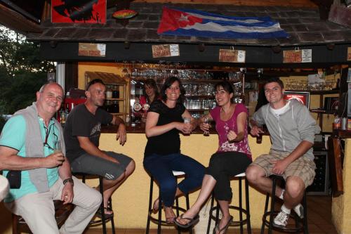 a group of people sitting in bar stools at Camping-Hotel de Plein Air Les 2 Bois in Baratier