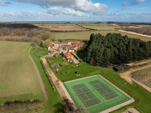 an aerial view of a tennis court in a field at Tern Place in Kelling