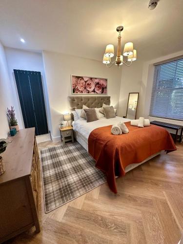 a bedroom with a large bed with a orange blanket at Luxury Pet Friendly 3 Bedroom Home with Copper Bath in Bowness-on-Windermere